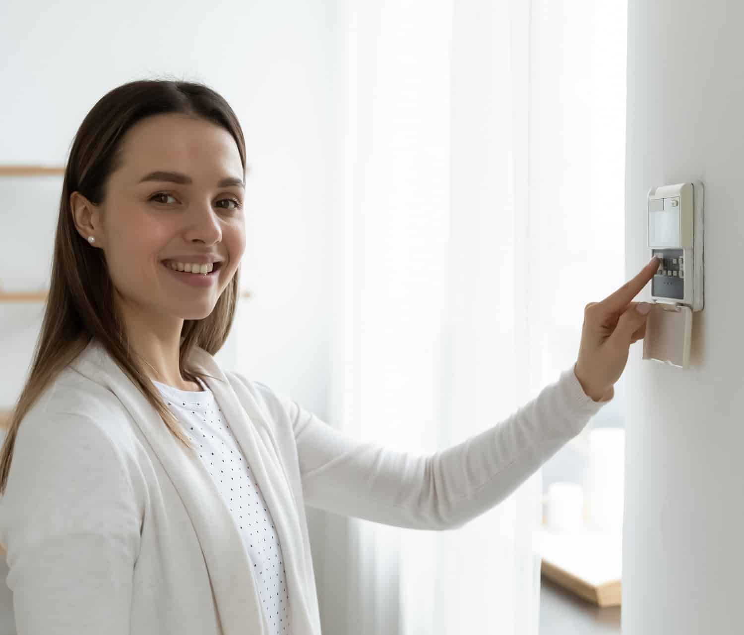 Happy young female client using smart house system.